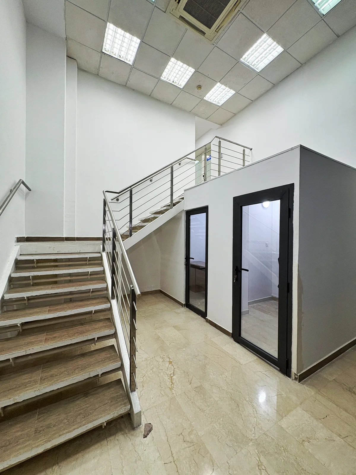 Palier desservant les bureaux privatifs, escalier et portes vitrées